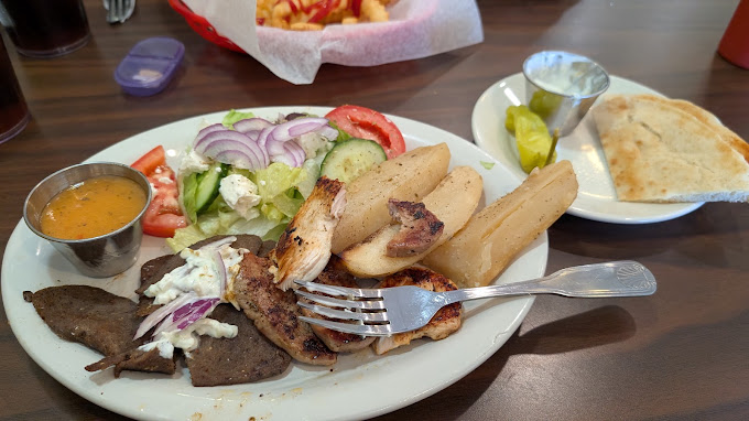 Greek combination plate with salad, pita, and grilled meats
